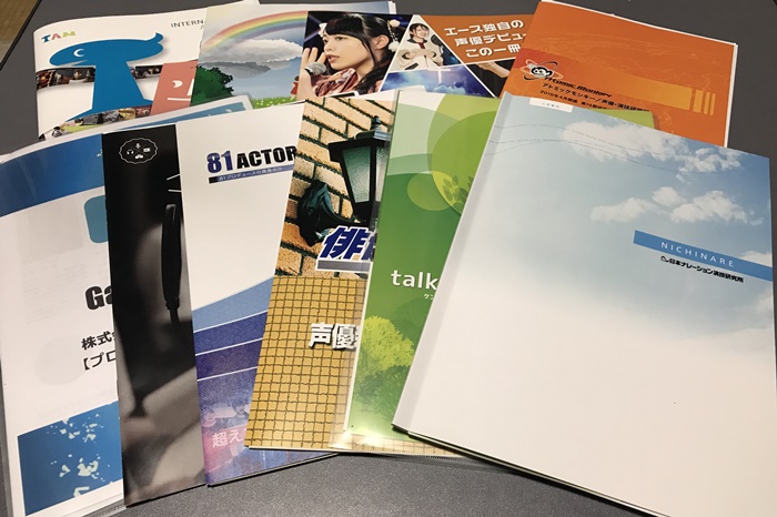 声優学校の資料やパンフレットを見比べて追加費用を確認するイメージ写真