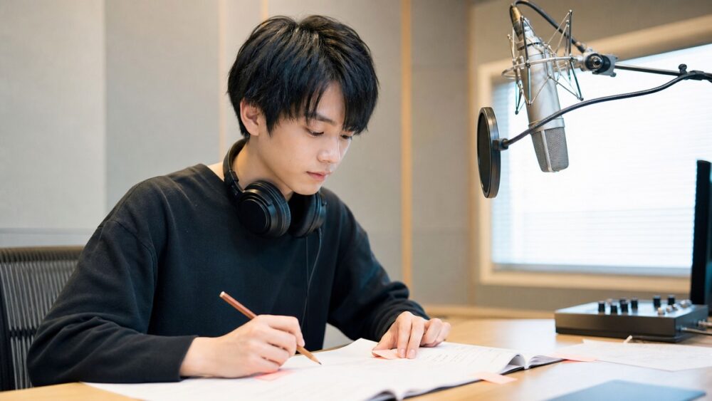 台本にメモをしながらセリフを覚える声優志望者の写真