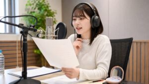 ボイスサンプル作成のためにマイク前で台本を読み録音しているイメージ写真