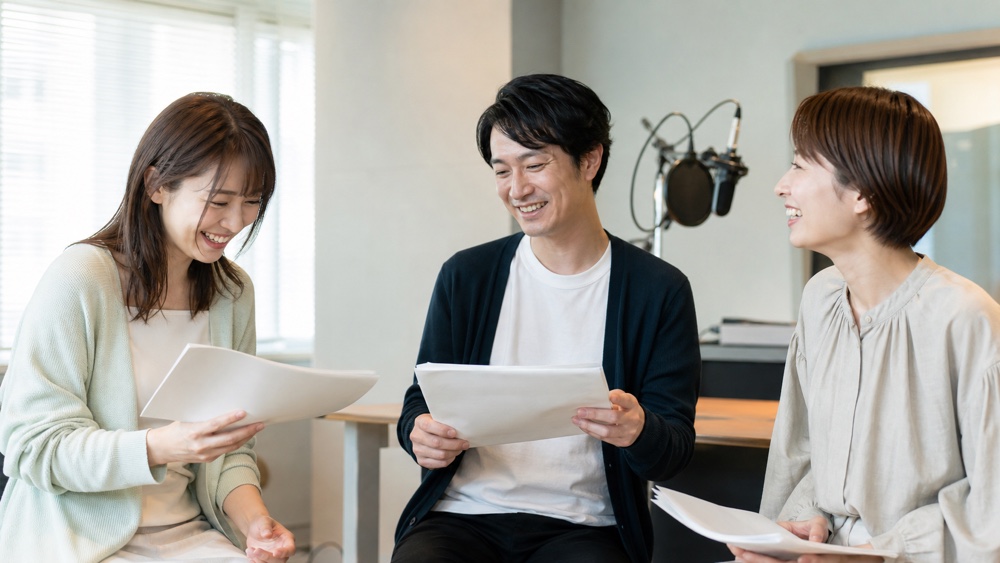 声優レッスン後に台本を見ながら良い体験を共有する受講生たち