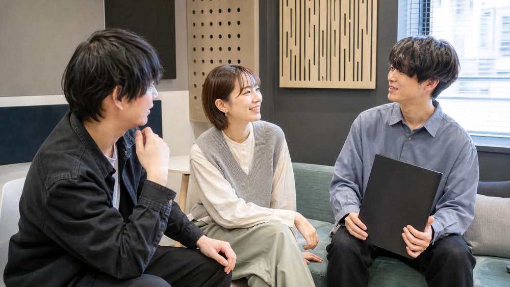 声優養成所の卒業生が経験を語り合うイメージ