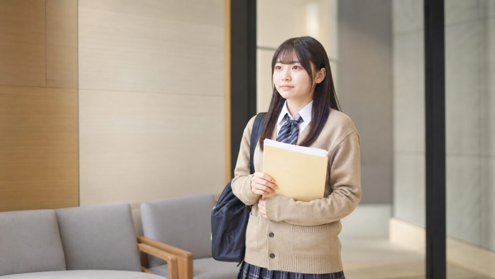 日ナレのオーディション会場で応募書類を持ち面接を待つ女子高生のイメージ