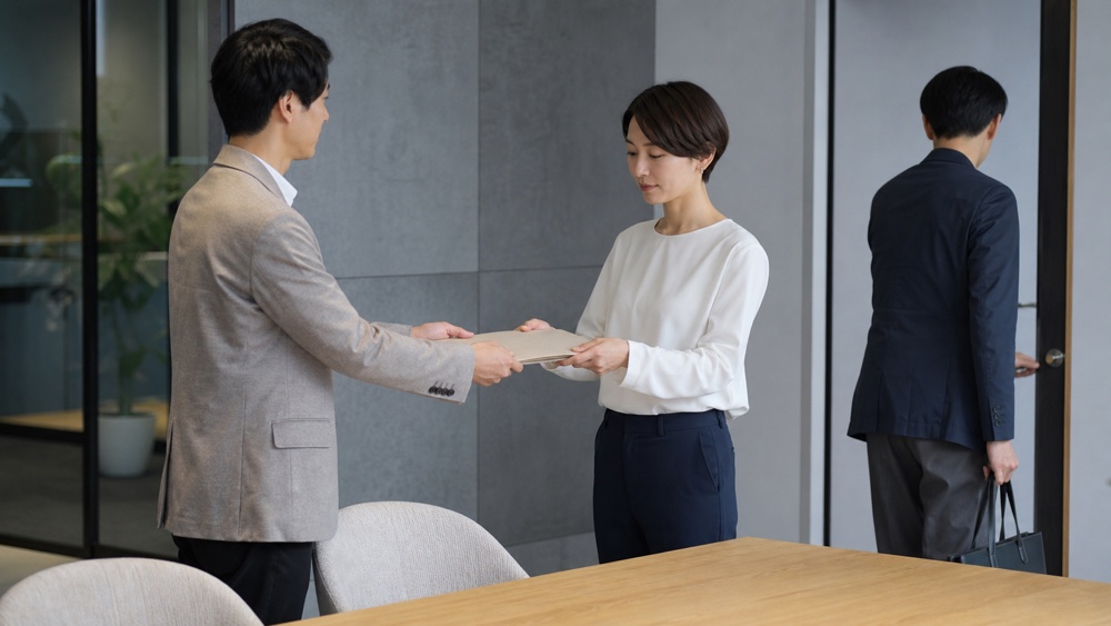 資料の引き継ぎと人の移動を表す中立的なイメージ