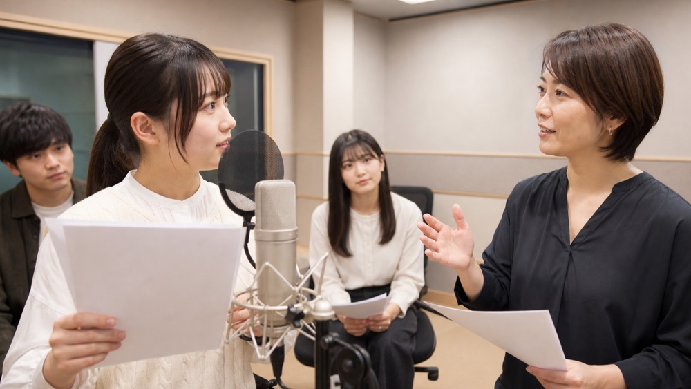 少人数の声優レッスンで講師から個別指導を受ける学生