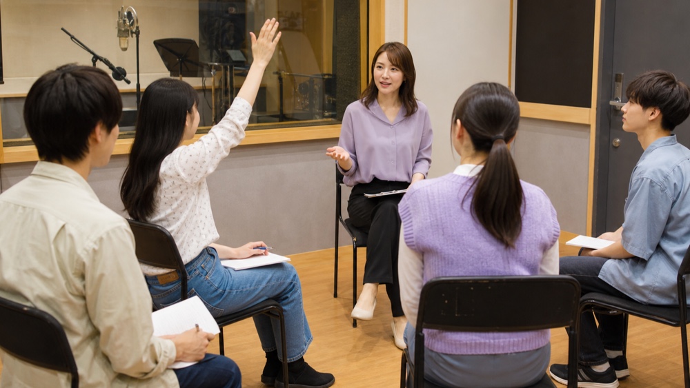 声優専門学校の進路説明会で質問する学生