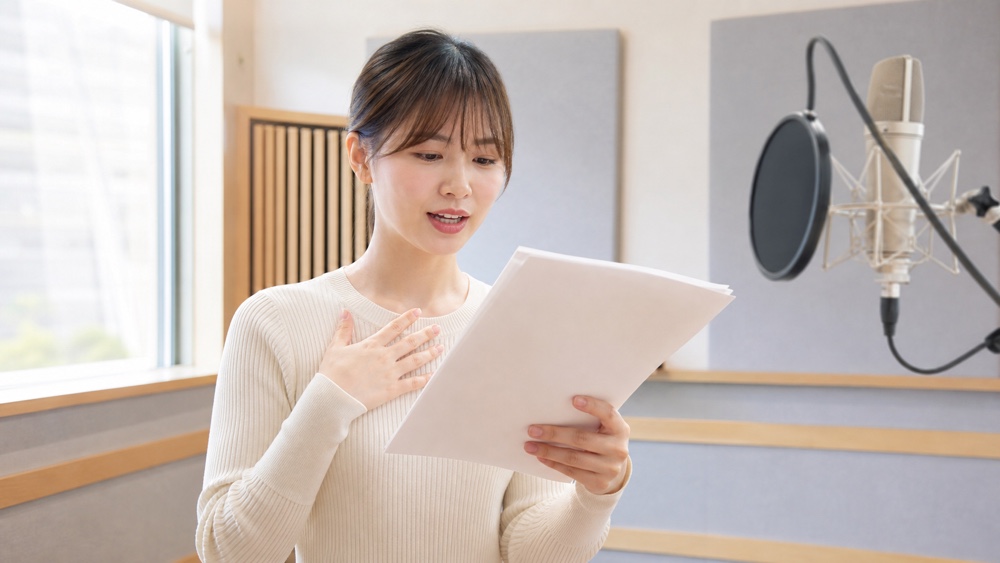 台詞の録音を聞き返して感情と伝わり方を確認する声優志望者