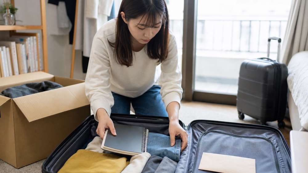 東京・大阪の声優専門学校を目指して上京の荷造りをする学生