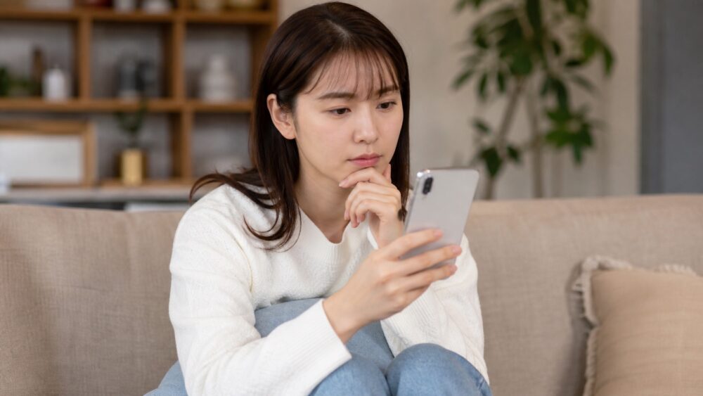 学校の口コミをスマホで確認する学生のイメージ