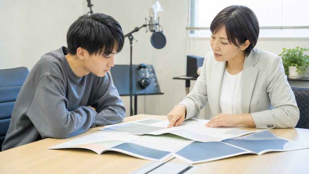 声優専門学校卒業後の進路について資料を見比べながら相談する学生