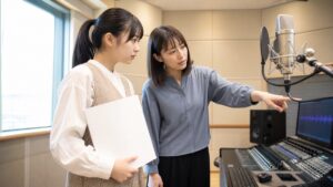 仙台の声優専門学校を検討し録音後の音声を講師と確認する声優志望者