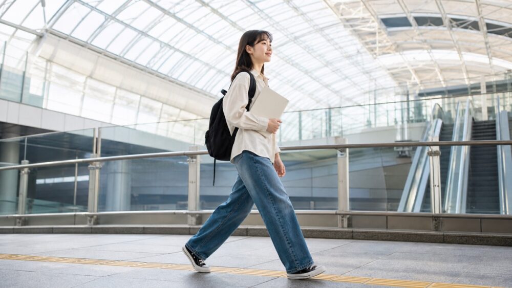 難波駅周辺を想起させる駅構内をレッスンへ向かう女性
