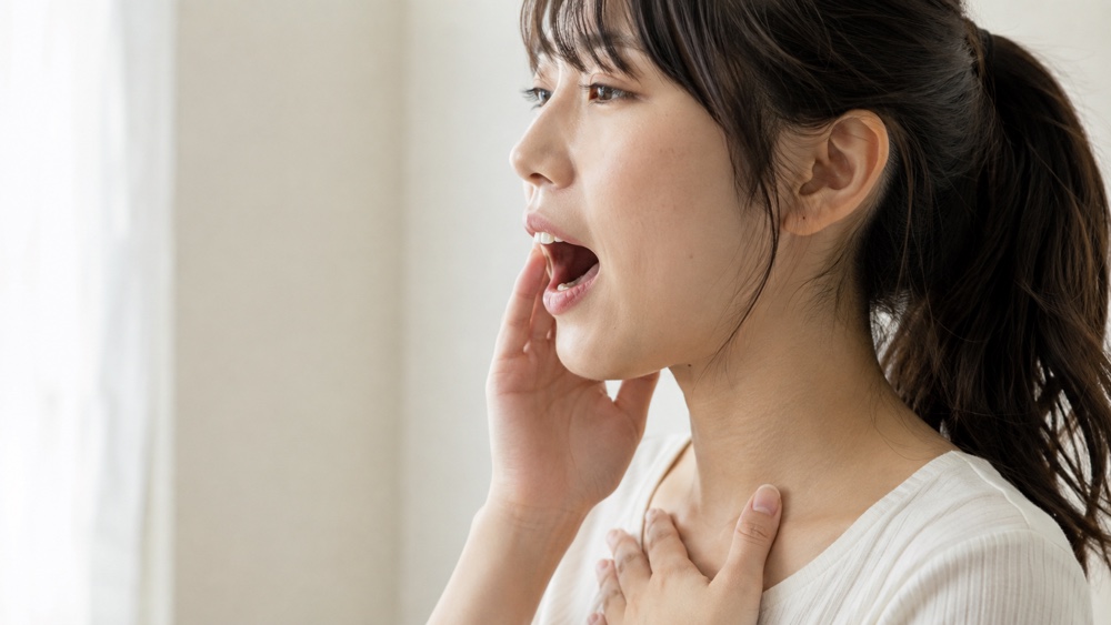 口元と喉の響きを意識して発声する女性