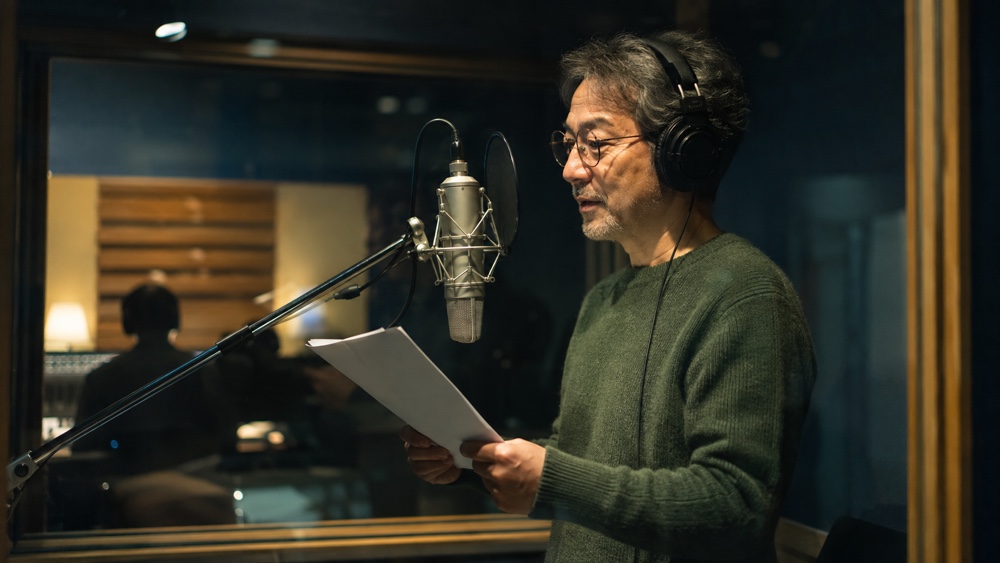 録音ブースでナレーション原稿を読む経験者