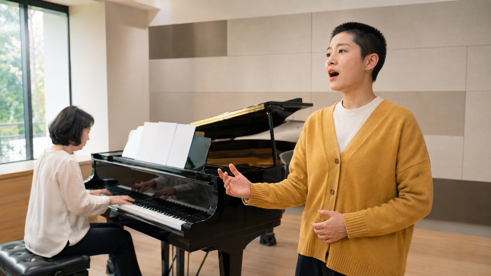 ピアノ伴奏に合わせて歌唱と表現を練習する一般的なアーティストレッスン