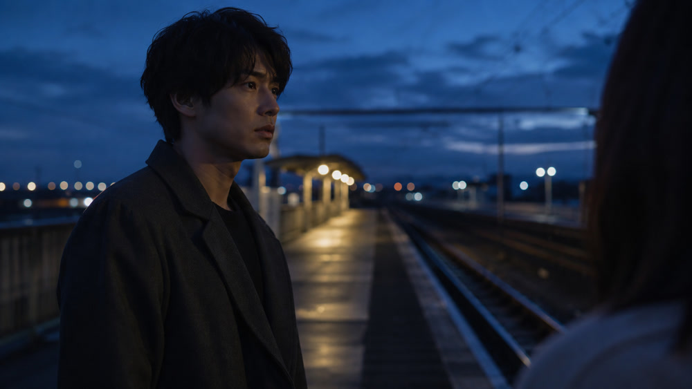 夕暮れの駅で静かな別れを告げる男性