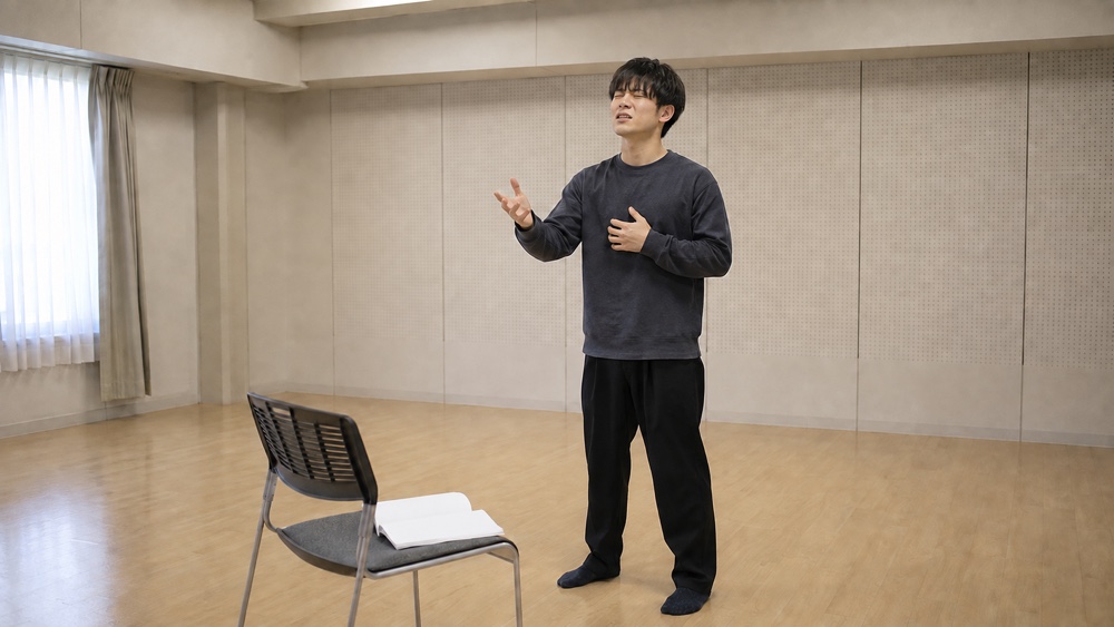 台本を覚えるために練習室で繰り返し演じる男性