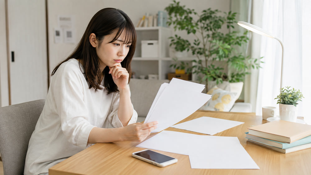 台本とスマホを前に練習用セリフ選びで悩む声優志望の女性