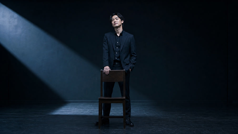 冷酷で勝ち誇る悪役を静かに演じる男性