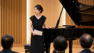 演奏本番前にピアノの横で落ち着こうとする女性