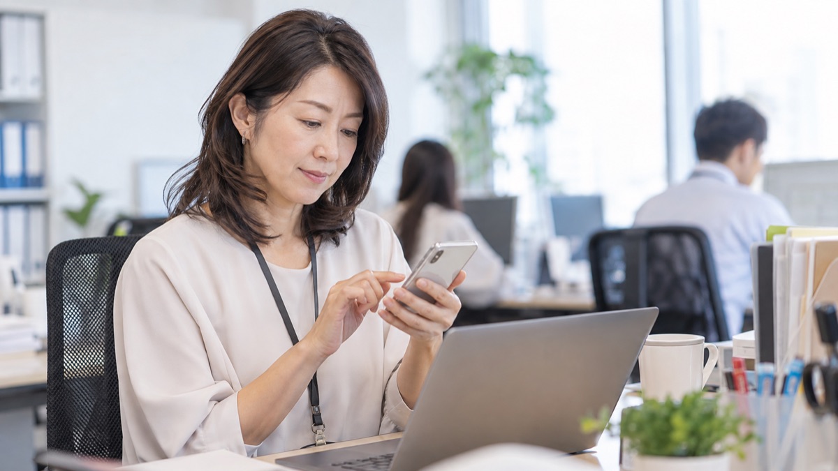 スマートフォンにメモを入力する女性社員