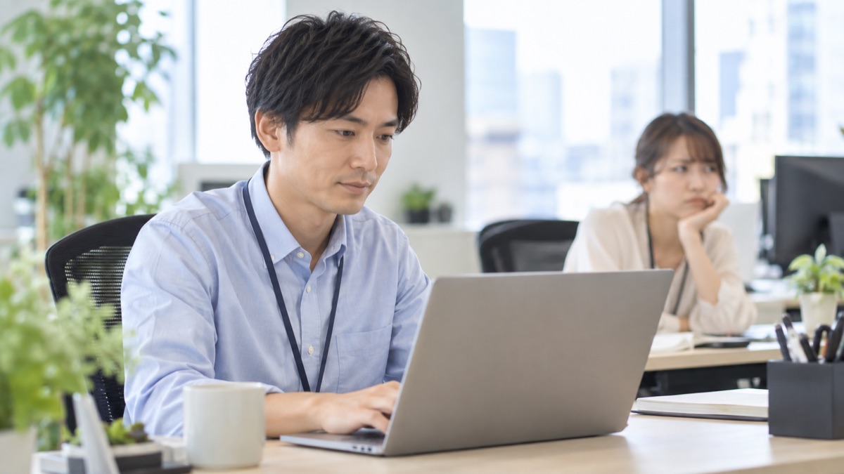 不機嫌な同僚から離れて自分の仕事に集中する男性