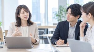 打ち合わせで言葉を選びながら説明する女性社員