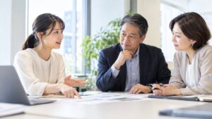 明るい会議室で上司と同僚に穏やかに意見を伝える女性会社員