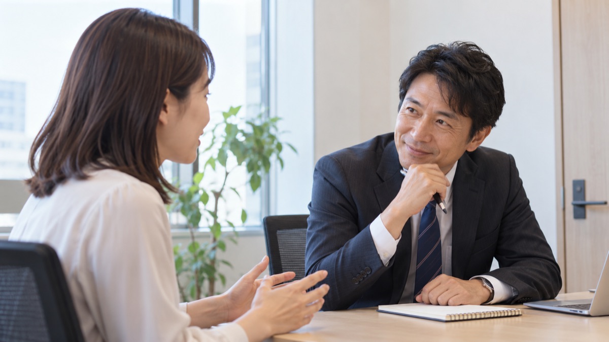 1on1の小部屋で、部下の話に身を乗り出して聞く男性上司