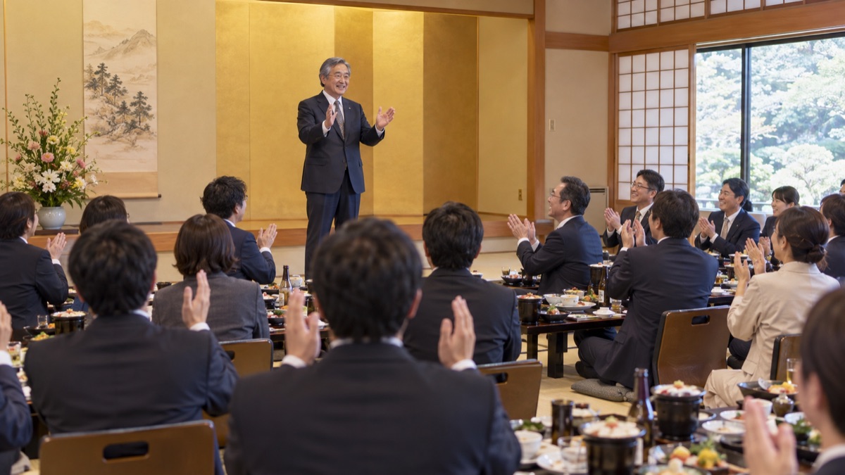宴会の終わりに、部長が立ち上がり手締めの合図をしようと両手を構えている