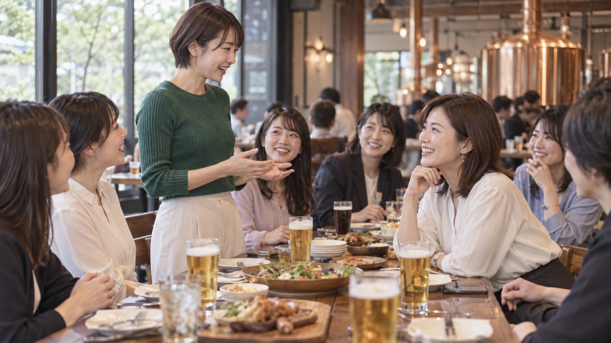 ビアホールの長テーブルで、同僚代表の若手が主役に向かって送る言葉を話している