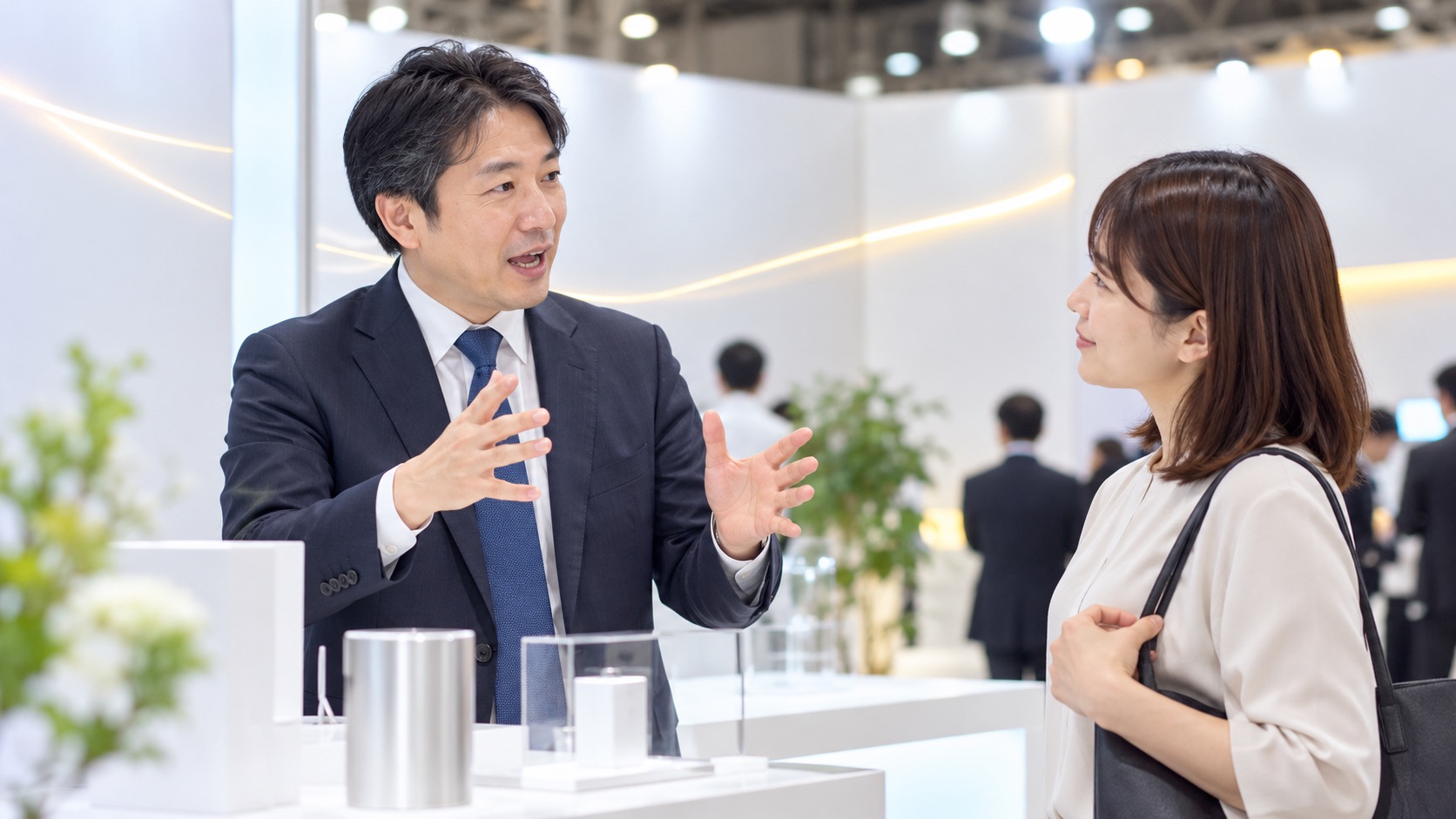 展示会のブースで来場者にはっきり説明する男性