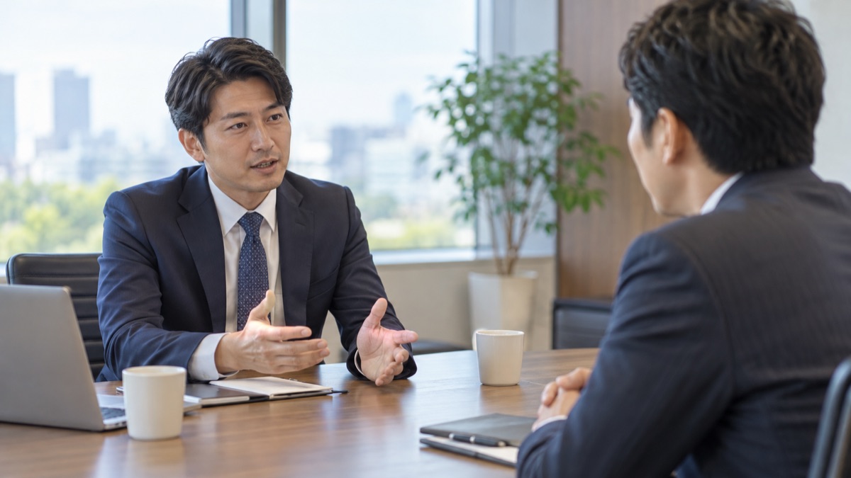 取引先との打ち合わせで、相手の話を言い直して確かめる男性営業