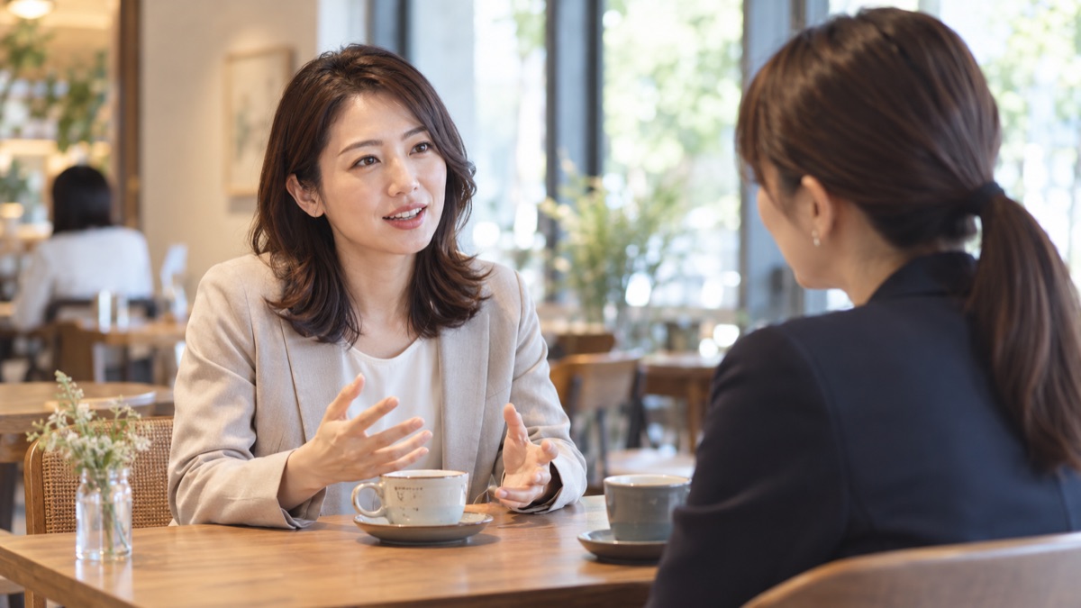 カフェで同僚と1対1で向き合い自分の考えを話す女性社員