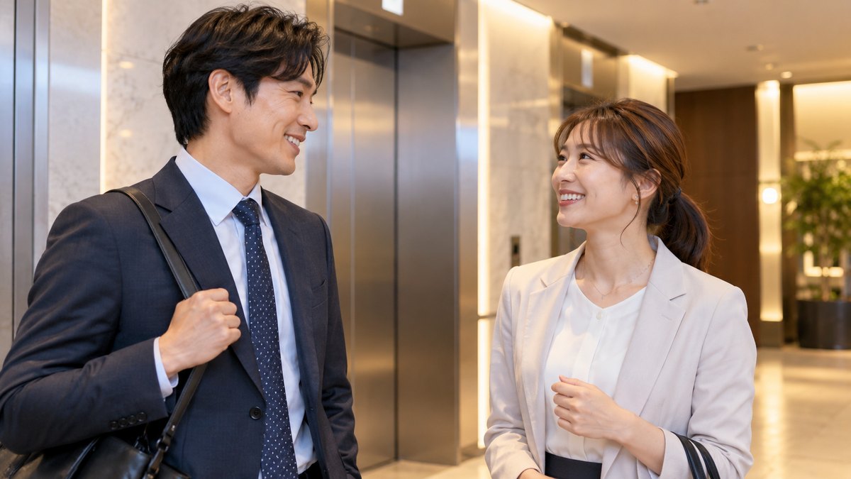 夕方、オフィスビルの明るいエレベーターホールで、仕事帰りの30代の男女の会社員がエレベーターを待ちながら、笑顔で話している近景。表示パネルや案内板の文字は見えない