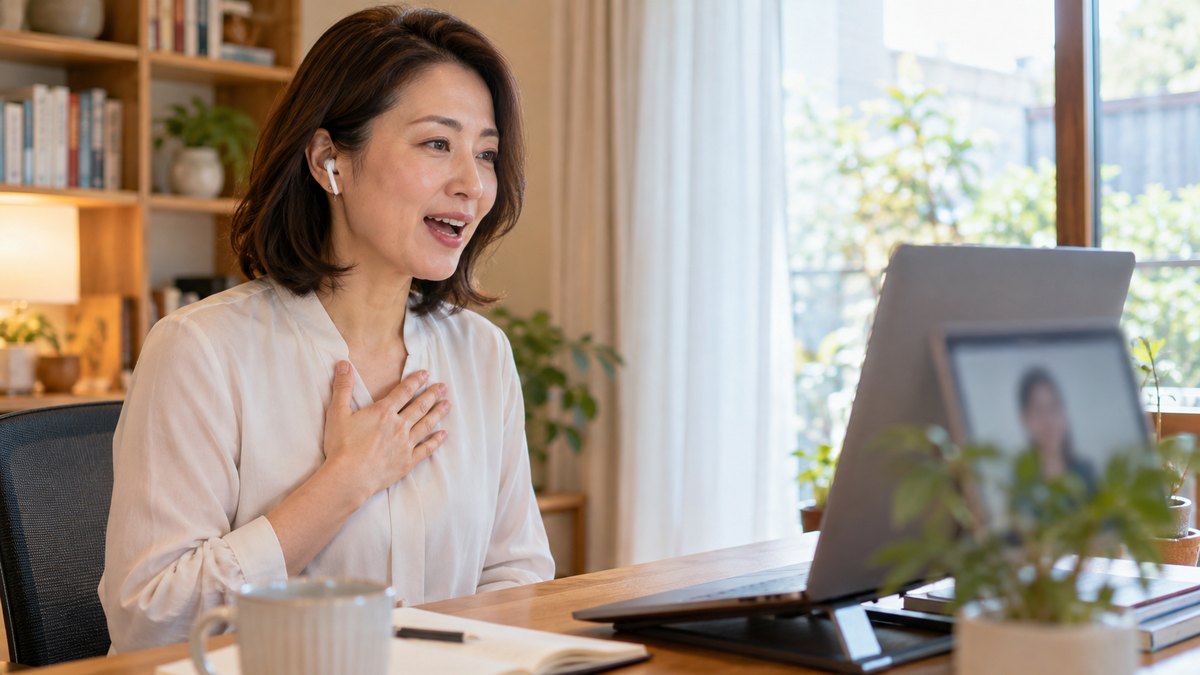 自宅の書斎でノートパソコンに向かい、イヤホンをつけてオンラインのボイトレを受ける女性会社員