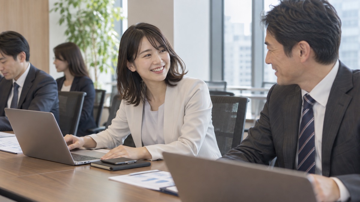 会議室で、会議が始まる前に隣の同僚に話しかける女性会社員