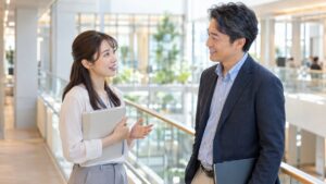 オフィスの通路で同僚に穏やかに一言話しかける女性会社員