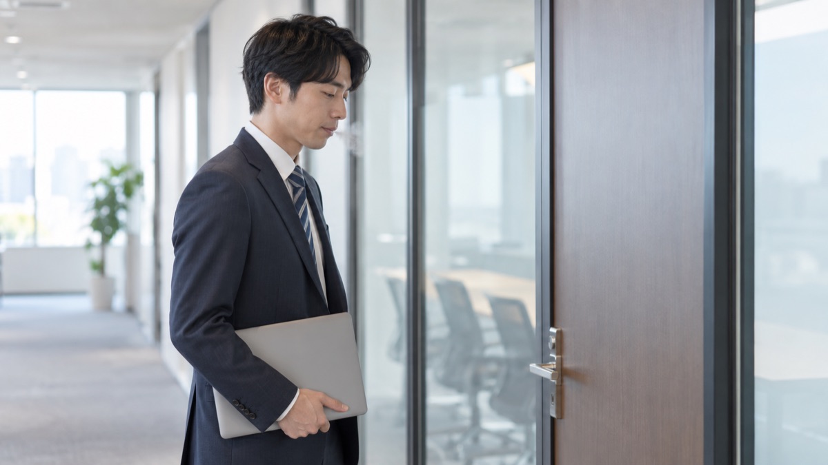 会議室の前で立ち止まり、小さく息を吐く男性社員