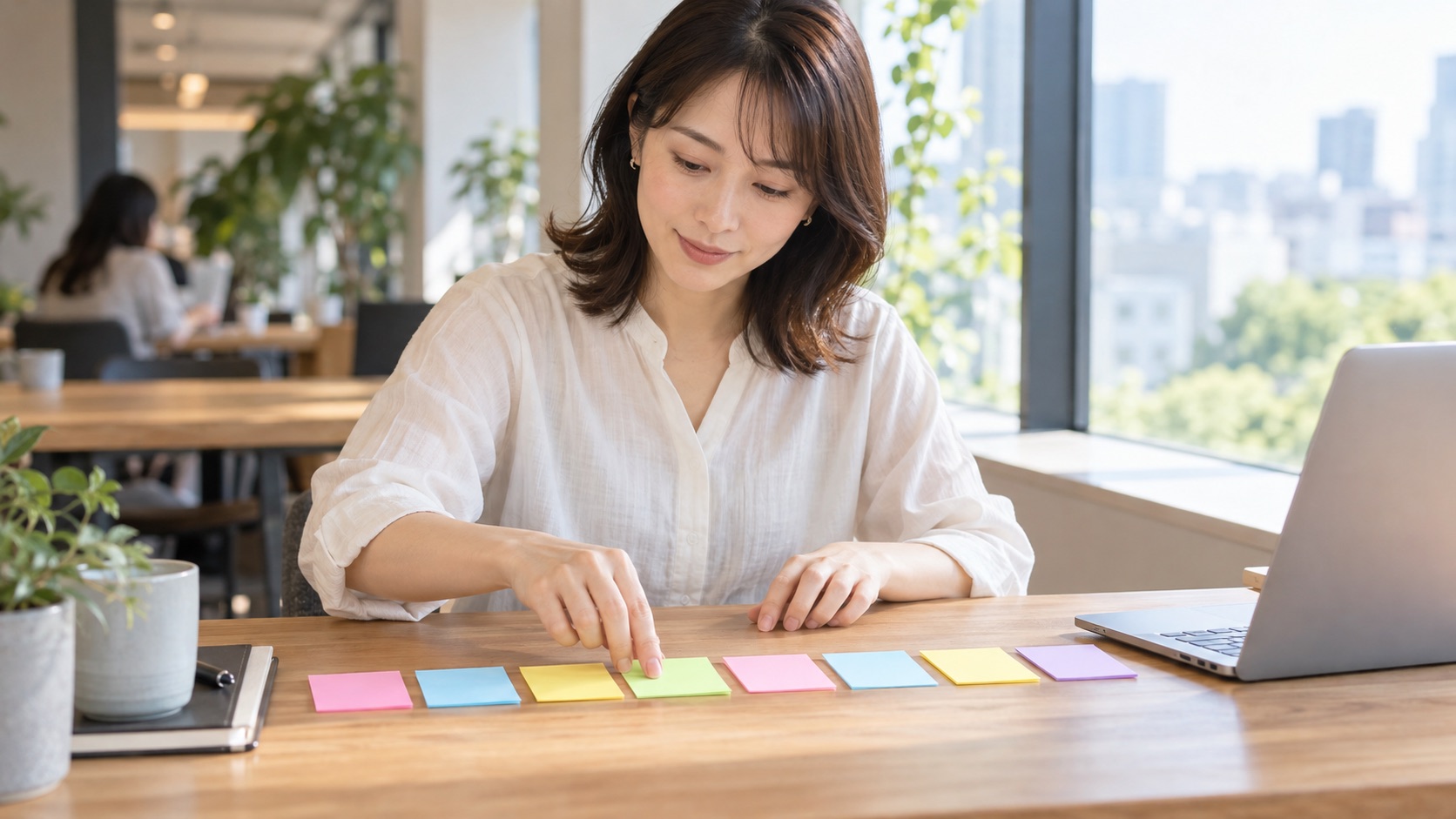 付箋を机に並べて取り組む順番を入れ替える女性