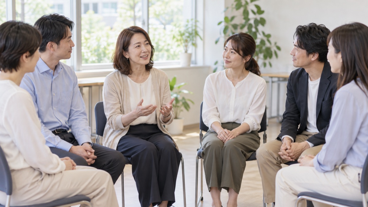 研修室で輪になって座り、順番に一言ずつ話す社会人たち