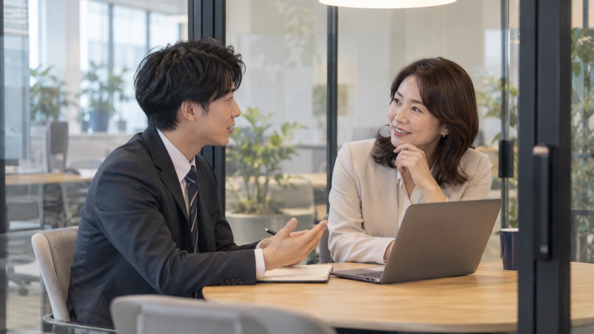 面談ブースで年上の社員に質問しながら話を聞く若手社員