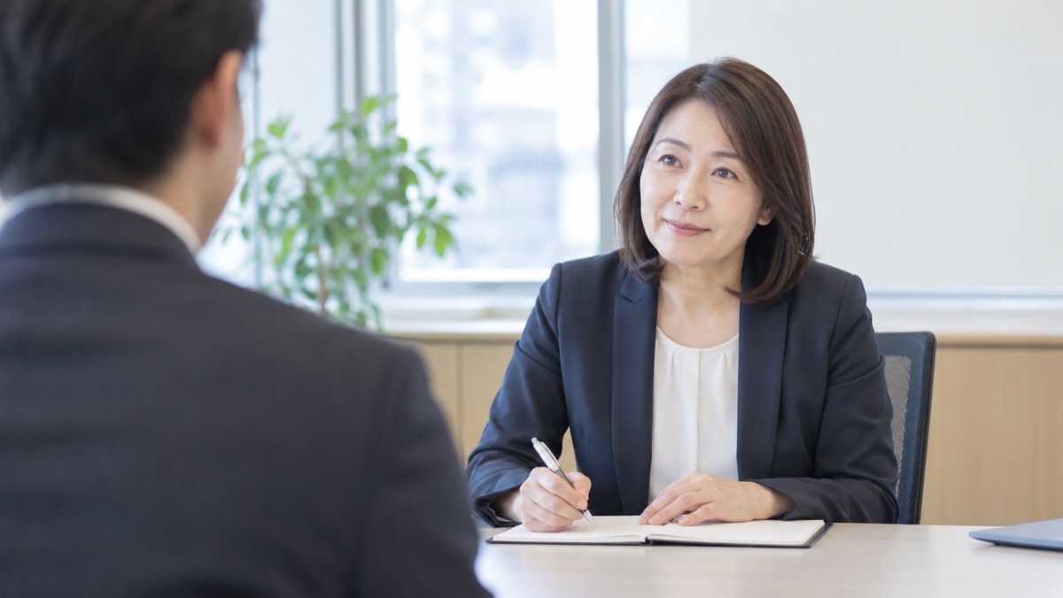 面接官の席から見た、メモを取りながら応募者の話にうなずく中年の女性面接官