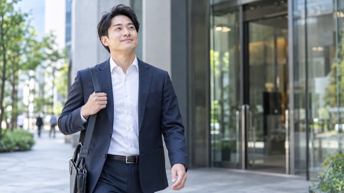 面接を終えてオフィスビルの外に出て、ほっとした表情で歩き出す30代の男性