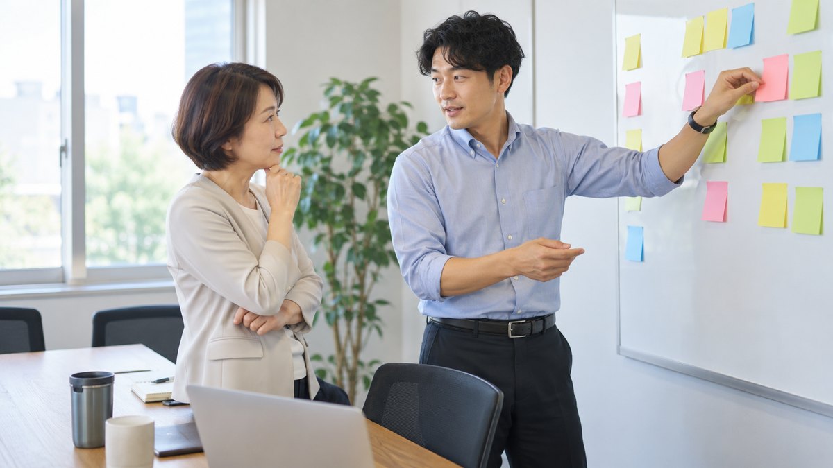 昼、会社の小さな打ち合わせ室で、幹事の30代の男性が壁に色とりどりの付箋を並べ、40代の女性課長と話す順番を相談している。付箋の文字は読めない
